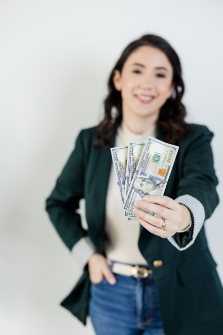 Sara smiling, holding cash